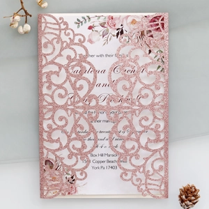 Detailed laser-cut glitter wedding invitation with watercolor floral design insert