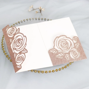 Detail of laser-cut rose gold wedding card with glitter paper and floral hollow pattern