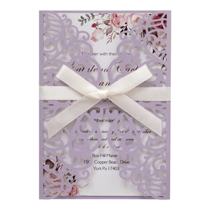 Navy blue laser-cut wedding invitation with white ribbon and floral inner card