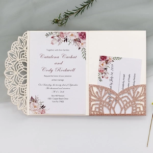 Macro view of laser cut wedding invitation with glitter detail and floral pattern print