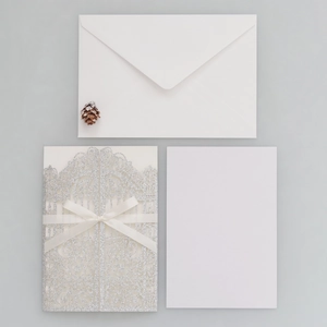 Set inviti intagliati al laser con copertina glitterata argento e fiocco in nastro bianco