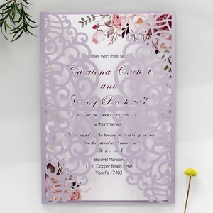 Detail of laser-cut heart and vine pattern on a purple wedding invitation with floral insert