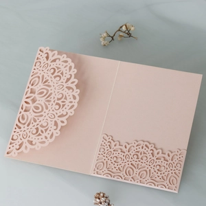 Detail of laser-cut mandala lace pattern on elegant pink wedding invitation pocket