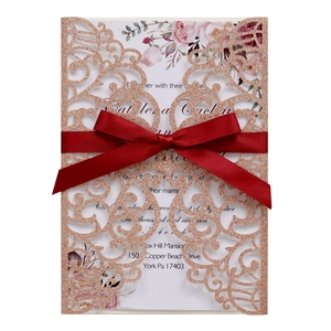 Elegant laser-cut glitter paper wedding invitation with red silk ribbon and floral insert