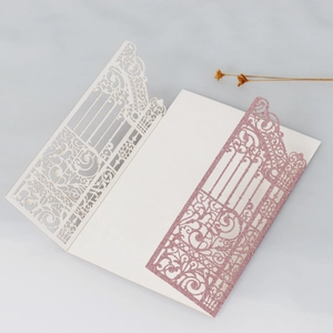 Vista macro dell'invito avorio tagliato al laser con carta glitter rosa e motivi floreali