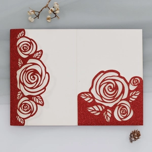 Macro detail of laser-cut red glitter wedding invitation with elegant rose pattern