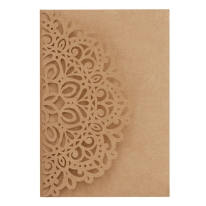 Close-up of laser-cut mandala patterns on brown kraft paper wedding invitation card