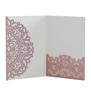 Detail of laser-cut glitter paper wedding invitation with intricate mandala patterns