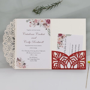 Detail of glitter laser-cut wedding invitation with elegant floral insert and red accents