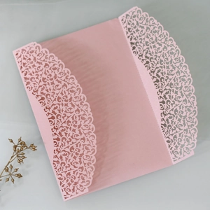 Macro detail of laser cut floral invitation card in pink pearlescent paper finish