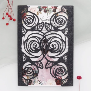 Detailed laser-cut rose pattern on black glitter wedding invitation card with floral insert