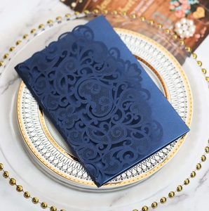 Detailed laser-cut hollow pattern on dark blue wedding invitation card with pearlescent finish