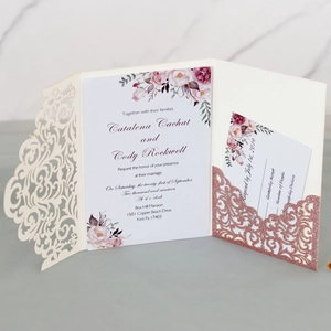 Detail of laser-cut wedding invitation with floral insert and rose gold glitter pocket