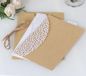 Detail view of rustic laser-cut lace invitation card with kraft paper and hemp rope