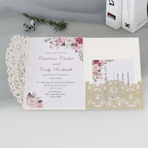 Detail of laser-cut mandala wedding invitation with floral insert and gold glitter pocket
