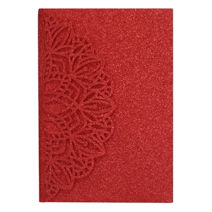 Macro detail of red glitter wedding invitation with laser cut mandala lace pattern