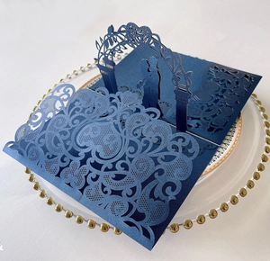 Detail of dark blue laser-cut 3D wedding card with intricate couple silhouette pattern