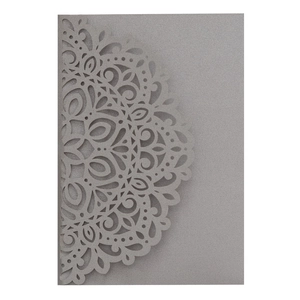 Detail of silver laser-cut mandala pattern on pearlescent wedding invitation card