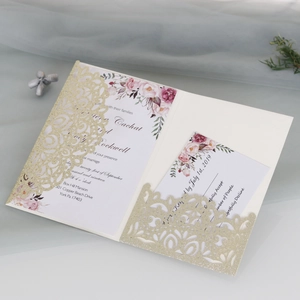 Detail view of laser-cut gold glitter wedding invitation with floral inner card and RSVP card
