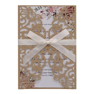 Detailed laser-cut brown kraft wedding invitation with white ribbon and floral print