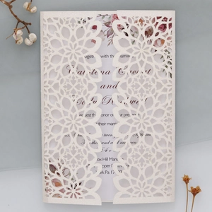 Macro detail of laser-cut mandala wedding invitation with shimmering glitter finish