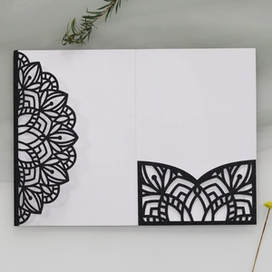 Detail of laser-cut black glitter wedding invitation with elegant mandala hollow patterns