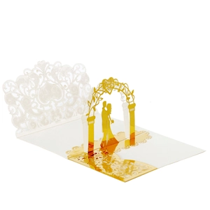 Detail of 3D laser-cut wedding card featuring gold silhouettes of a couple under an arch