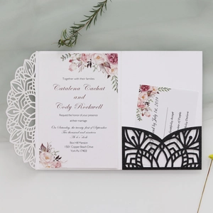 Close-up of laser-cut wedding invitation with glitter sleeve and floral detail