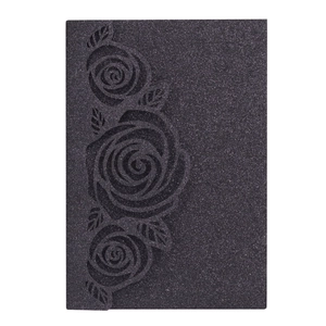 Detail of laser-cut black rose design on glitter paper wedding invitation cover