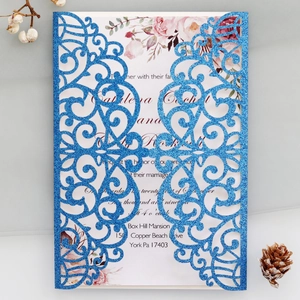 Macro detail of royal blue glitter laser cut lace envelope and floral wedding card insert