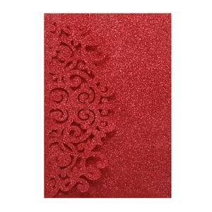Dettaglio dell'invito di nozze in carta glitterata rossa con motivi floreali intagliati