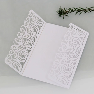 Elegant white laser-cut wedding invitation card with intricate swirl and cloud patterns