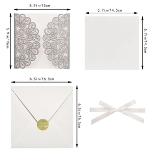 Detail view of laser-cut wedding invitation kit with silver glitter cover and ribbon bow