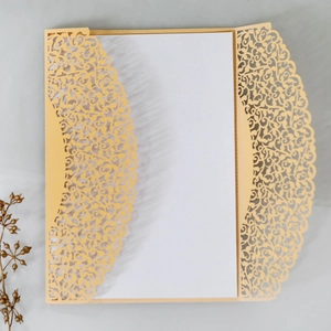 Detail of laser-cut floral invitation cover in champagne gold with white insert card