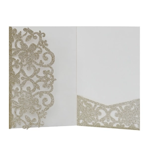 Dettaglio dell'invito di nozze glitterato oro champagne con design floreale traforato