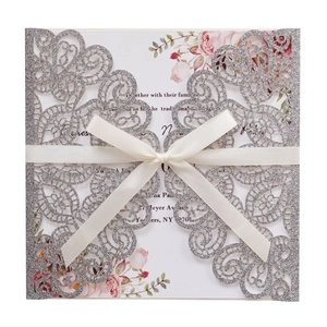 Elegant laser cut wedding invitation with silver glitter finish and silk ribbon bow