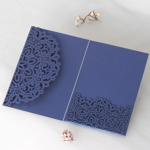 Detail of laser-cut mandala lace pattern on navy blue wedding invitation card pocket