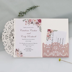 Detail of laser-cut wedding invitation with glitter pocket and floral inner card