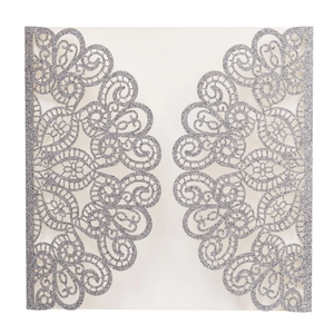 Detail view of silver glitter laser-cut wedding invitation with intricate lace floral patterns
