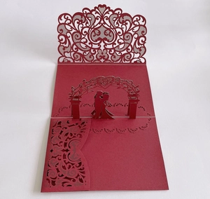 Detail of laser-cut 3D pop-up wedding invitation card showing a couple under a floral arch