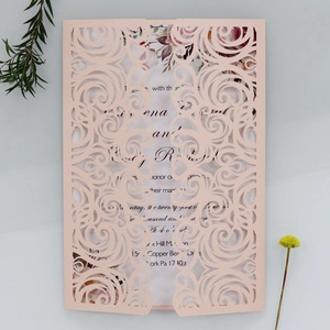 Laser-cut floral scroll wedding invitation detail in soft pink with vintage inserts