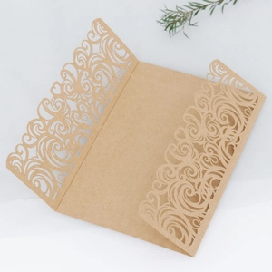 Kraft paper laser cut wedding invitation with vintage floral pattern on white backdrop