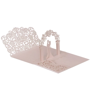Detail of laser-cut 3D pop-up wedding card featuring a romantic floral arch and couple