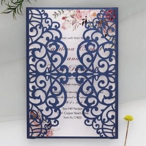 Detail of laser-cut navy invitation with vintage floral pattern and elegant handwriting