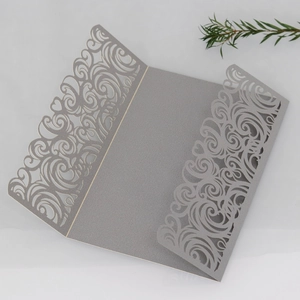 Macro detail of laser-cut lace pattern on grey pearlescent wedding invitation card