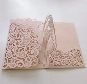 Close-up of laser-cut lace details and 3D pop-up structure on pink hollow invitation