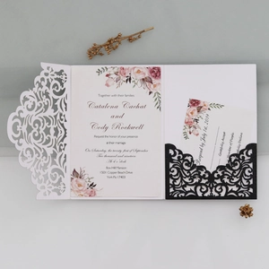 Close-up of laser-cut wedding invitation set with floral print and glitter paper texture