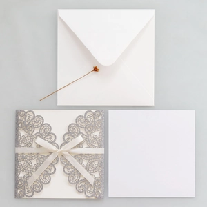 Three-piece silver glitter laser cut wedding invitation set with white ribbon bow