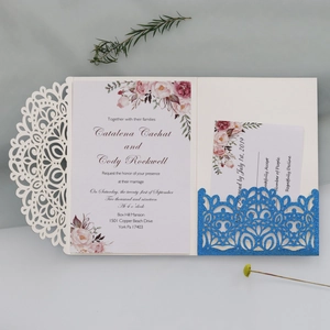 Close-up of laser-cut wedding invitation set with intricate mandala lace and floral card