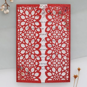 Intricate laser-cut red glitter wedding invitation with floral hollow pattern detail